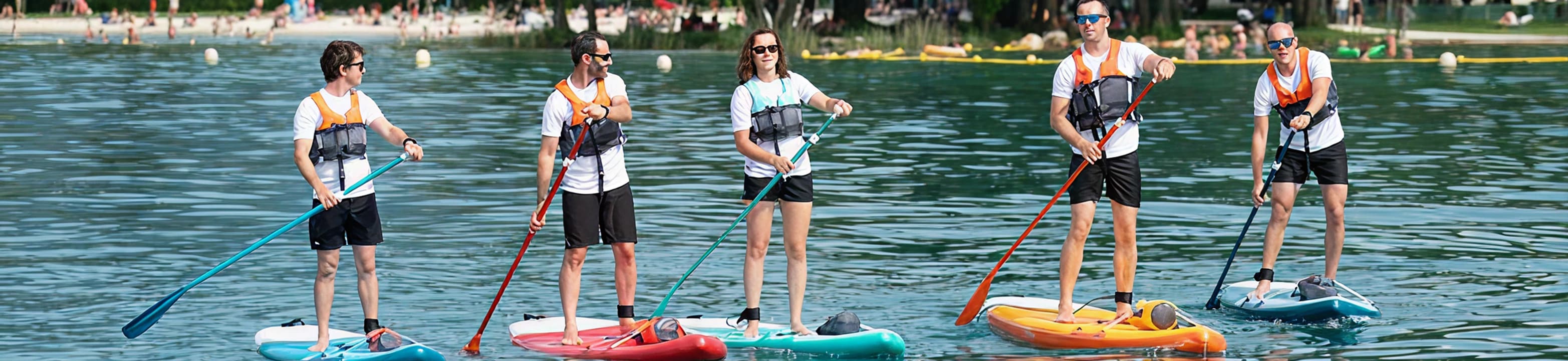 Group of friends paddleboarding on a New Zealand lake at sunset