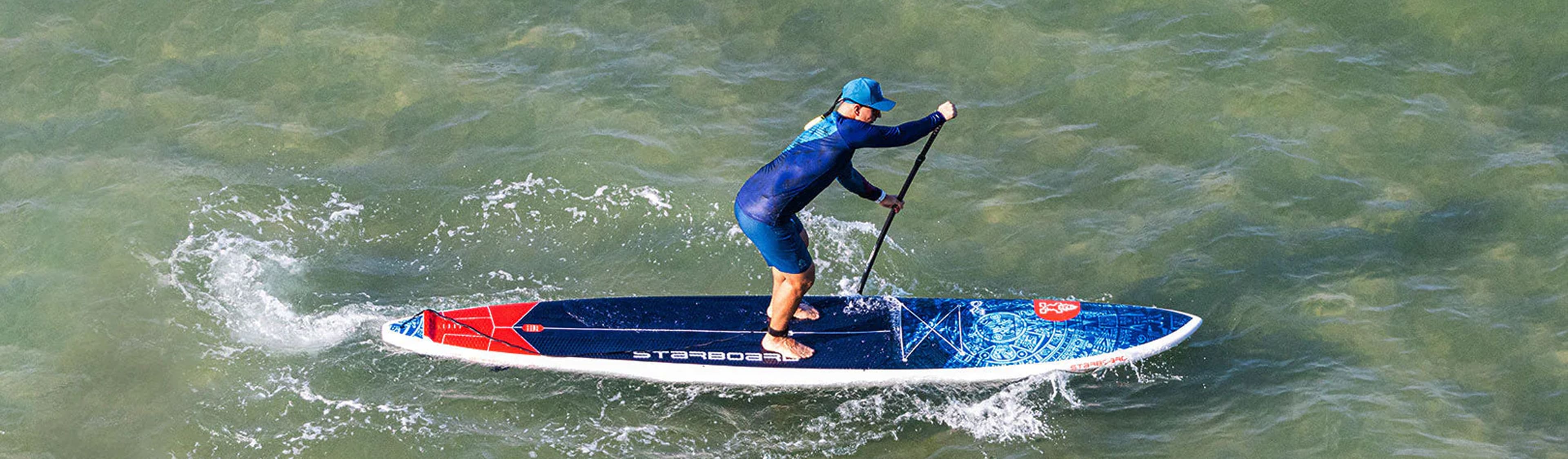 Beginner paddleboarding on a calm New Zealand lake